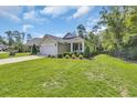 Beautifully landscaped front yard with a charming light green exterior and inviting porch at 628 Grand Cypress Way, Murrells Inlet, SC 29576