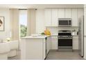 Modern kitchen with stainless steel appliances, white cabinets, an island, and a window at 6347 Swainson Street Sw, Ocean Isle Beach, NC 28469
