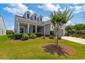Lovely home featuring dormer windows and a welcoming covered porch, surrounded by lush landscaping and manicured lawn at 6378 Torino Lane, Myrtle Beach, SC 29572
