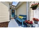 Inviting front porch with bench seating, a decorative wreath, and colorful potted flowers at 6681 Wisteria Dr., Myrtle Beach, SC 29588