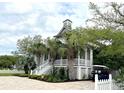 Charming coastal home with a front porch, a well-manicured yard, and convenient golf cart parking at 70 Beachwalker Ct., Georgetown, SC 29440