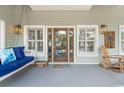 Relaxing front porch featuring a swing, rocking chair, and coastal decor, perfect for enjoying the outdoors at 70 Beachwalker Ct., Georgetown, SC 29440