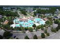 Aerial view of a large community pool with multiple pools, sun decks, palm trees and parking at 7183 Shooting Star Way, Myrtle Beach, SC 29579