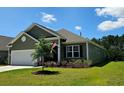 Beautiful single-story home boasts green siding, attached garage and lush, green lawn at 784 Flowering Branch Ave., Little River, SC 29566