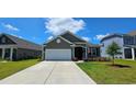Inviting single-story home featuring a well-manicured lawn and an attached two car garage at 784 Flowering Branch Ave., Little River, SC 29566