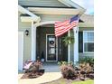 Welcoming front porch with American flag, attractive door decor and landscaped garden at 784 Flowering Branch Ave., Little River, SC 29566