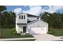 Two-story home featuring a two-car garage, light blue siding, black roof, and tropical landscaping at 859 Long Beach Dr, Longs, SC 29568