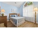 Cozy bedroom with a vaulted ceiling, light blue walls, and a large arched window for natural light at 106 Cypress Creek Dr., Murrells Inlet, SC 29576