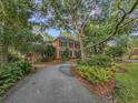 Attractive brick home with a long driveway, lush landscaping, and mature trees at 1073 Crooked Oak Dr., Pawleys Island, SC 29585
