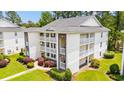 Angled view of the three story condo building with balconies, brick accents and manicured lawn at 1208 River Oaks Dr. # 24-B, Myrtle Beach, SC 29579