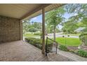 Relaxing covered porch with brick flooring and a view of the landscaped front yard and quiet street at 1468 Fox Hollow Way, North Myrtle Beach, SC 29582