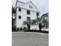 Charming white three-story home with palm trees and a three-car garage at 17 Carson Creek Dr., Murrells Inlet, SC 29576