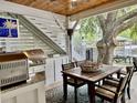 Covered outdoor kitchen area with a grill, a dining table and a beautiful view at 17 Carson Creek Dr., Murrells Inlet, SC 29576