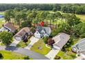 An aerial view of a home situated among trees with a golf course in the background at 2077 N Berwick Dr., Myrtle Beach, SC 29575