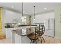 Bright, open kitchen with white cabinets, granite countertops, a central island, and pendant lighting for a modern touch at 213 South Myrtle Dr., Surfside Beach, SC 29575