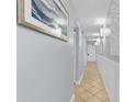 Long hallway features neutral paint, baseboards, and picture frame molding plus decorative lighting and tiled floors at 2609 South Ocean Blvd. # 702, North Myrtle Beach, SC 29582