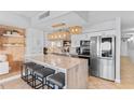 This modern kitchen features white cabinets, marble countertops, stainless steel appliances, and decorative pendant lighting at 2609 South Ocean Blvd. # 702, North Myrtle Beach, SC 29582