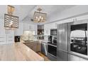 Modern kitchen features stainless steel appliances, white cabinets, marble countertops, and decorative pendant lighting fixtures at 2609 South Ocean Blvd. # 702, North Myrtle Beach, SC 29582