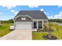 Charming home featuring a well-manicured lawn, stone accents, and a welcoming covered front porch at 305 Portofino Dr., Myrtle Beach, SC 29579