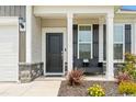 Inviting front porch with black front door, columns and stone accents at 305 Portofino Dr., Myrtle Beach, SC 29579