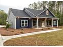 Inviting blue house with a gray brick base, and a charming front porch perfect for relaxing at 3200 Fowler School Rd., Loris, SC 29569