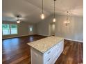 Open kitchen and living room with an island, hardwood flooring, and stylish pendant lighting at 3204 Fowler School Rd., Loris, SC 29569