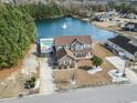Aerial view of the property showcasing the house, lake, pool, and surrounding neighborhood at 400 Dog Pen Ct., Myrtle Beach, SC 29588