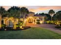 Beautiful home with lush landscaping, brick driveway, and a covered entry illuminated at dusk at 434 Posada Dr., Myrtle Beach, SC 29572
