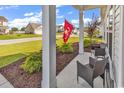 Inviting front porch with seating area and beautiful landscaping at 447 Honeyhill Loop, Conway, SC 29526