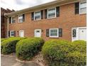 Exterior view of a brick townhouse featuring a neatly landscaped front yard with trimmed bushes at 4505 N Kings Hwy. # E2, Myrtle Beach, SC 29577