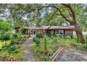 Charming home featuring brick exterior with lush landscaping, a stone walkway, and a screened in porch at 5114 Cowart Ct., Murrells Inlet, SC 29576