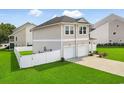 View of the side of the home highlighting the manicured lawn, fenced yard, and attached two-car garage at 79 S Reindeer Rd., Surfside Beach, SC 29575