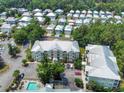 Expansive aerial view of a residential complex with multiple buildings, a pool, and lush green landscaping at 82 Mingo Dr. # 2D, Pawleys Island, SC 29585