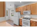 Bright kitchen features white appliances, wooden cabinets and tiled floors at 821 Laquinta Loop, Murrells Inlet, SC 29576