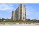 Exterior view of a high-rise condo building with multiple balconies, near the beach at 8560 Queensway Blvd. # 106, Myrtle Beach, SC 29572