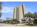 Exterior facade of a condo building with palms and meticulously maintained landscaping at 8560 Queensway Blvd. # 106, Myrtle Beach, SC 29572