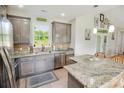 Well-lit kitchen with gray cabinetry, granite countertops, stainless steel appliances, and a breakfast bar at 1013 Happy Ln., Galivants Ferry, SC 29544
