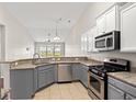Modern kitchen features granite countertops, stainless steel appliances, and stylish gray and white cabinetry at 121 Parmelee Dr. # D, Murrells Inlet, SC 29576