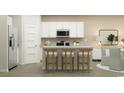 Modern kitchen featuring a kitchen island with a white countertop and wooden stools at 1708 Hunting Harris Ct # 2, Ocean Isle Beach, NC 28469