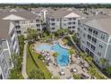 An aerial view of the community pool surrounded by condos, palm trees, and patio furniture at 172 Ella Kinley Circle # 101, Myrtle Beach, SC 29588