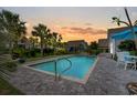 Inviting pool at dusk, featuring a brick patio, lush landscaping, and tranquil atmosphere for relaxation and enjoyment at 1833 Lake Egret Dr., North Myrtle Beach, SC 29582