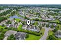 An aerial view pinpoints the home in a neighborhood near a lake and green spaces at 185 Fulbourn Pl., Myrtle Beach, SC 29579