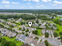 An aerial view pinpoints the home in a lush, green community with mature trees and winding roads at 185 Fulbourn Pl., Myrtle Beach, SC 29579