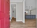 Welcoming entryway with hardwood floors, a vibrant red door, and a view into the modern kitchen at 2080 Silver Island Way, Murrells Inlet, SC 29576