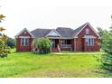 A charming brick home featuring a covered front porch and manicured green lawn at 2191 Jasmine Rd., Loris, SC 29569