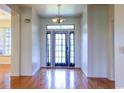 Welcoming foyer showcasing hardwood floors, a modern light fixture and a glass front door at 2191 Jasmine Rd., Loris, SC 29569