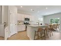 Modern kitchen with stainless steel appliances, granite countertops, and a breakfast bar overlooking the dining area at 234 Ladyfish Loop, Sunset Beach, NC 28468
