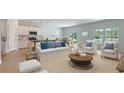 Open-concept living room featuring a modern kitchen, dining area and comfortable seating with lots of natural light at 234 Ladyfish Loop, Sunset Beach, NC 28468