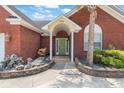 Close-up of a red brick home's inviting entryway, showcasing a neatly landscaped garden and charming front door at 2384 Covington Dr., Myrtle Beach, SC 29579