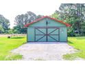 Well-maintained outbuilding with a metal roof and large sliding doors, perfect for storage or hobbies at 3150 Dusty Rd., Loris, SC 29569